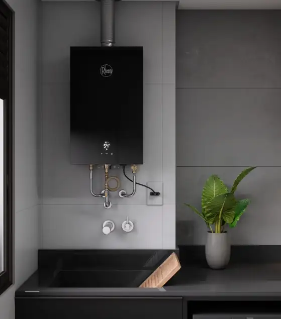 Aquecedor a gás preto instalado na parede de uma área de serviço, com conexões de água e gás aparentes